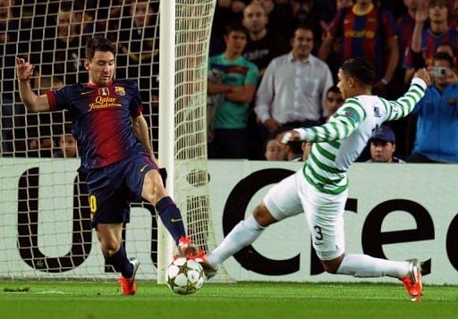Barcelona's Lionel Messi (L) vies with Celtic's Emilio Izaguirre